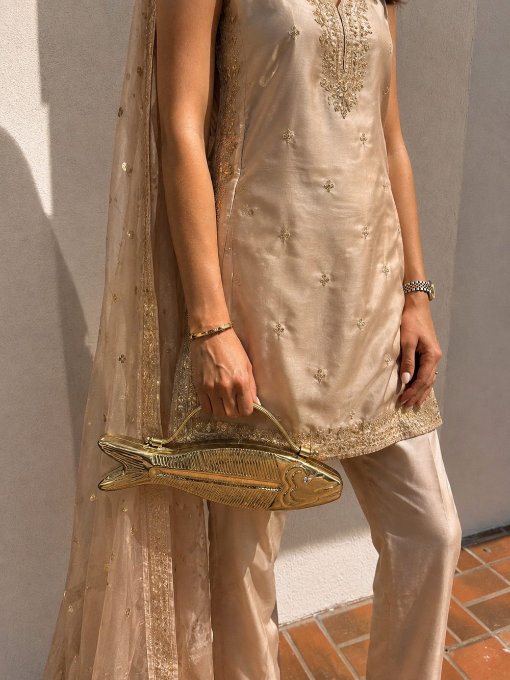 Azure Koi clutch carried by hand, styled with an embroidered gold Indian outfit