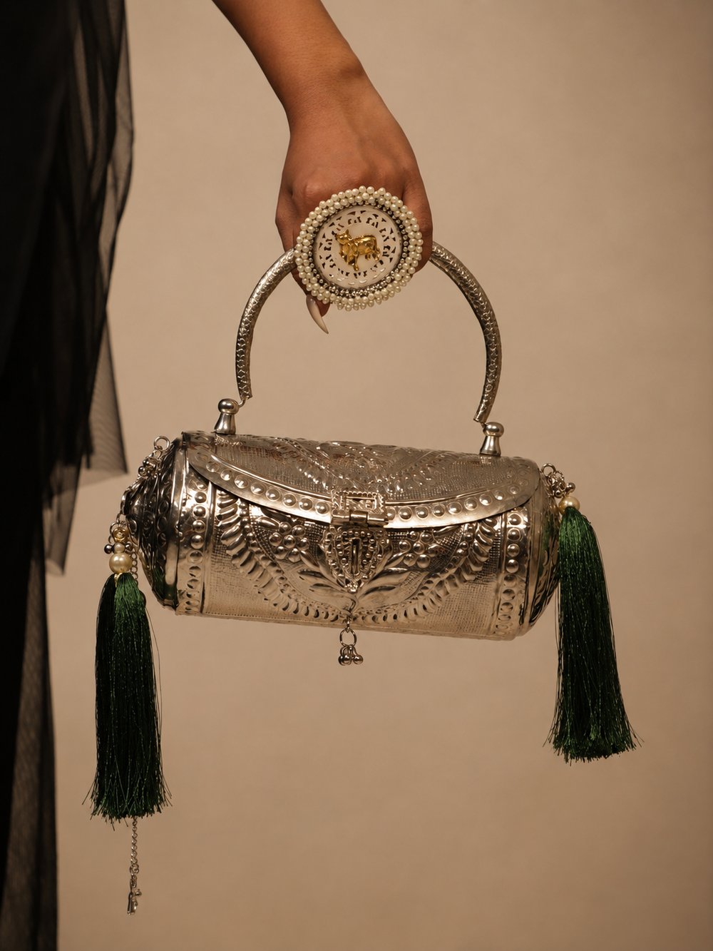 Close-up of Emerald Heirloom's round faux-pearl clasp and emerald-green tassels