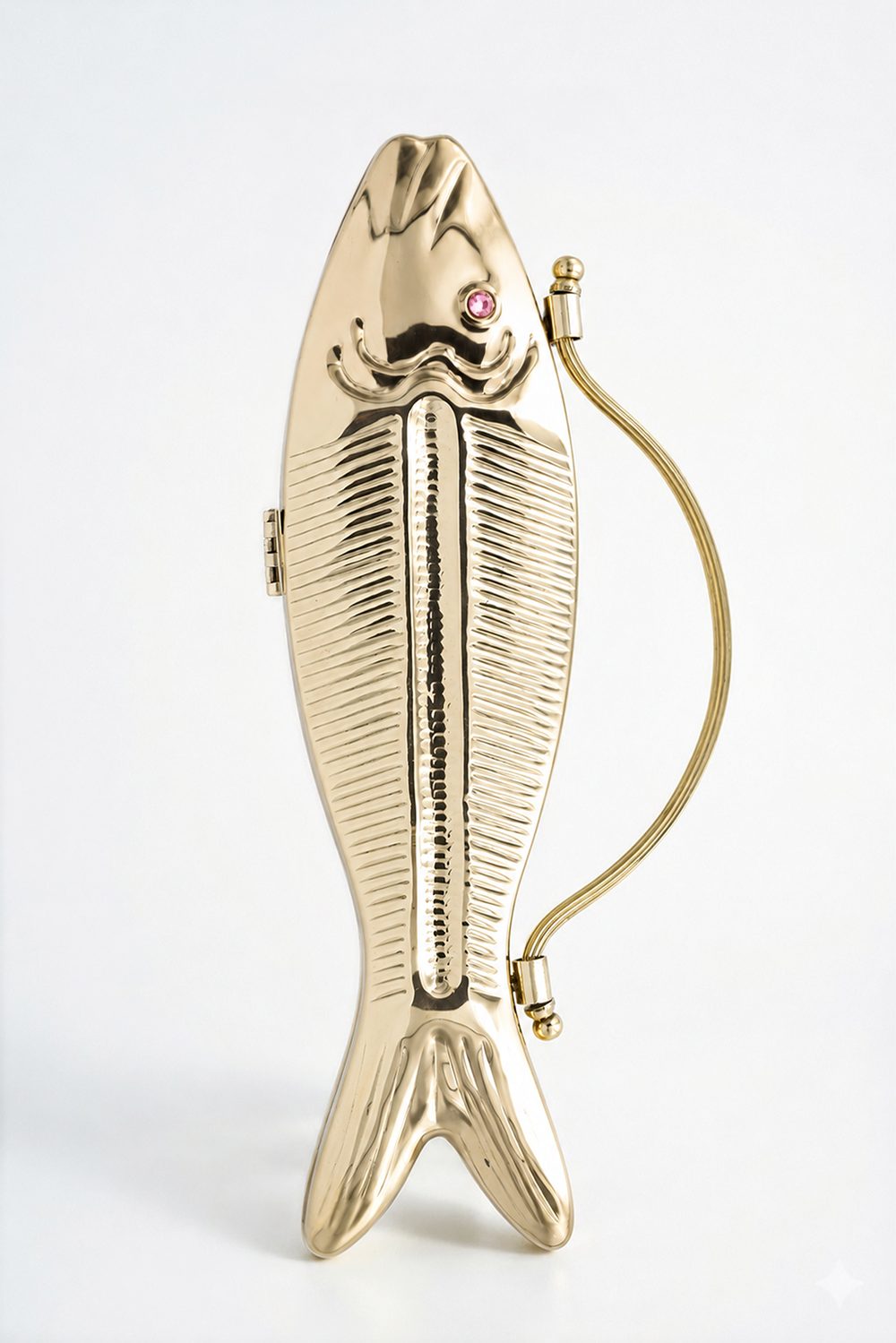 Ruby Koi gold-finish fish-shaped metal clutch with a pink stone eye, standing upright against a plain background