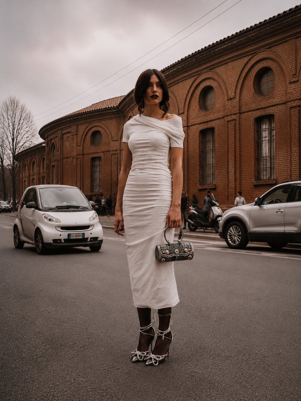 Noor-e-Raj clutch carried by its ring handle, styled with a white fitted dress on a city street