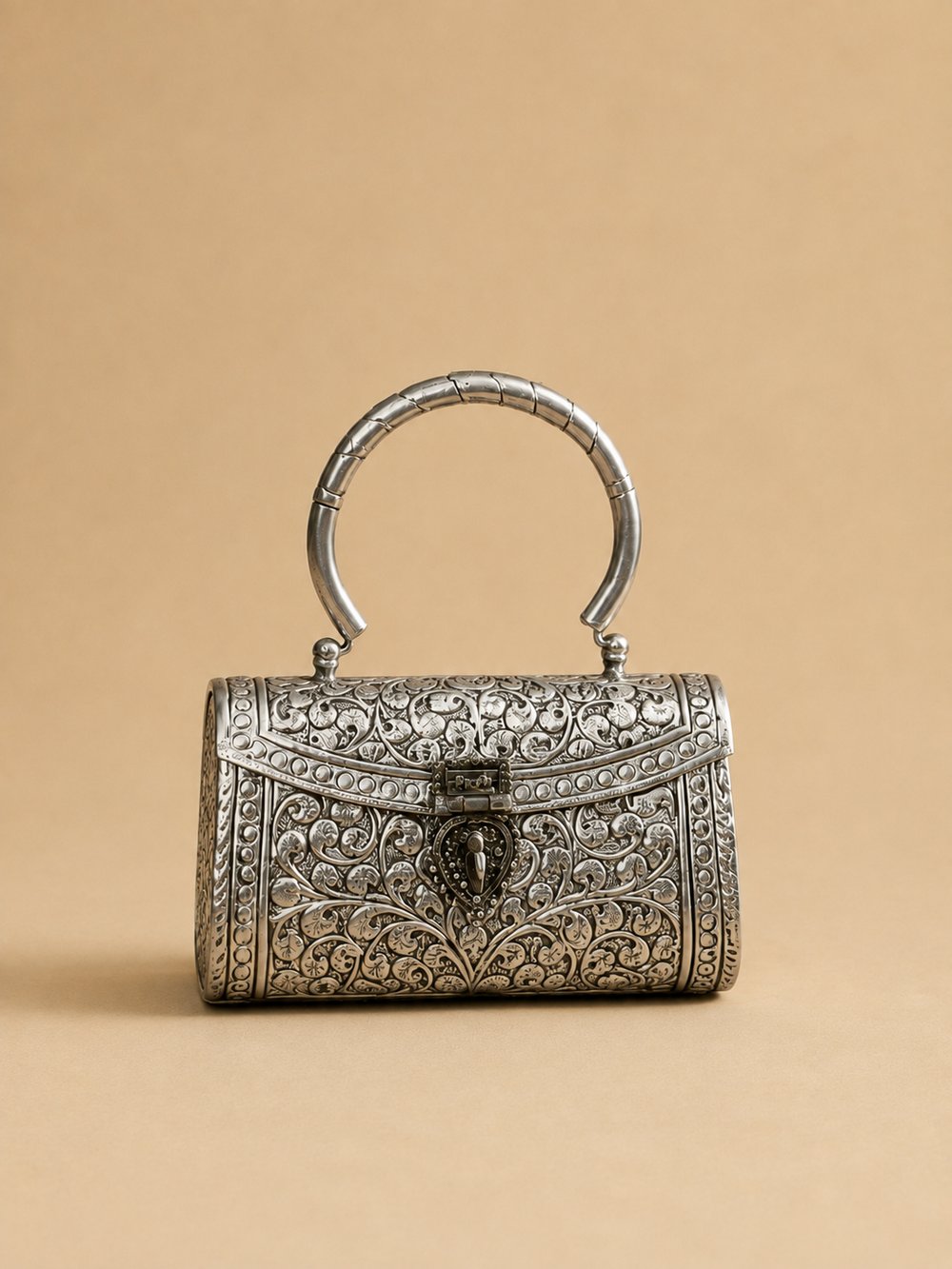 Noor Viraasat clutch shown from the front, showing the heart-shaped clasp and engraved scrollwork